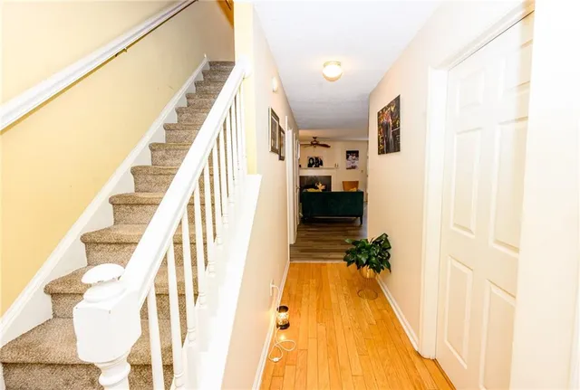 a view of a hallway with wooden floor and staircase