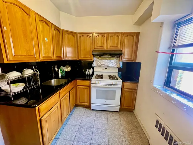 a kitchen with sink a stove and cabinets