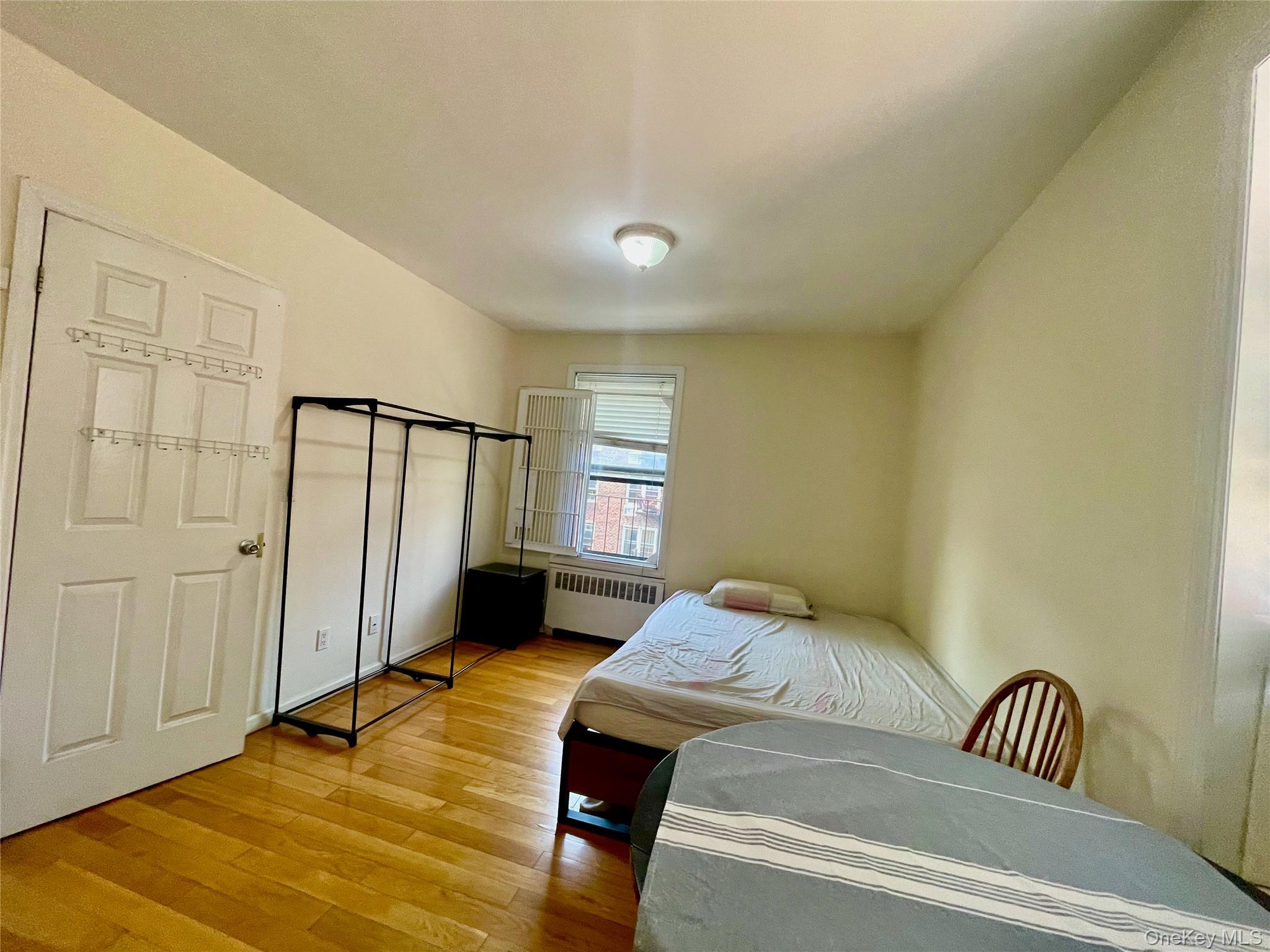 44-25 Macnish Street, Unit 5B Queens, NY 11373 - Photo 8 of 19 a bedroom with a bed and wooden floor
