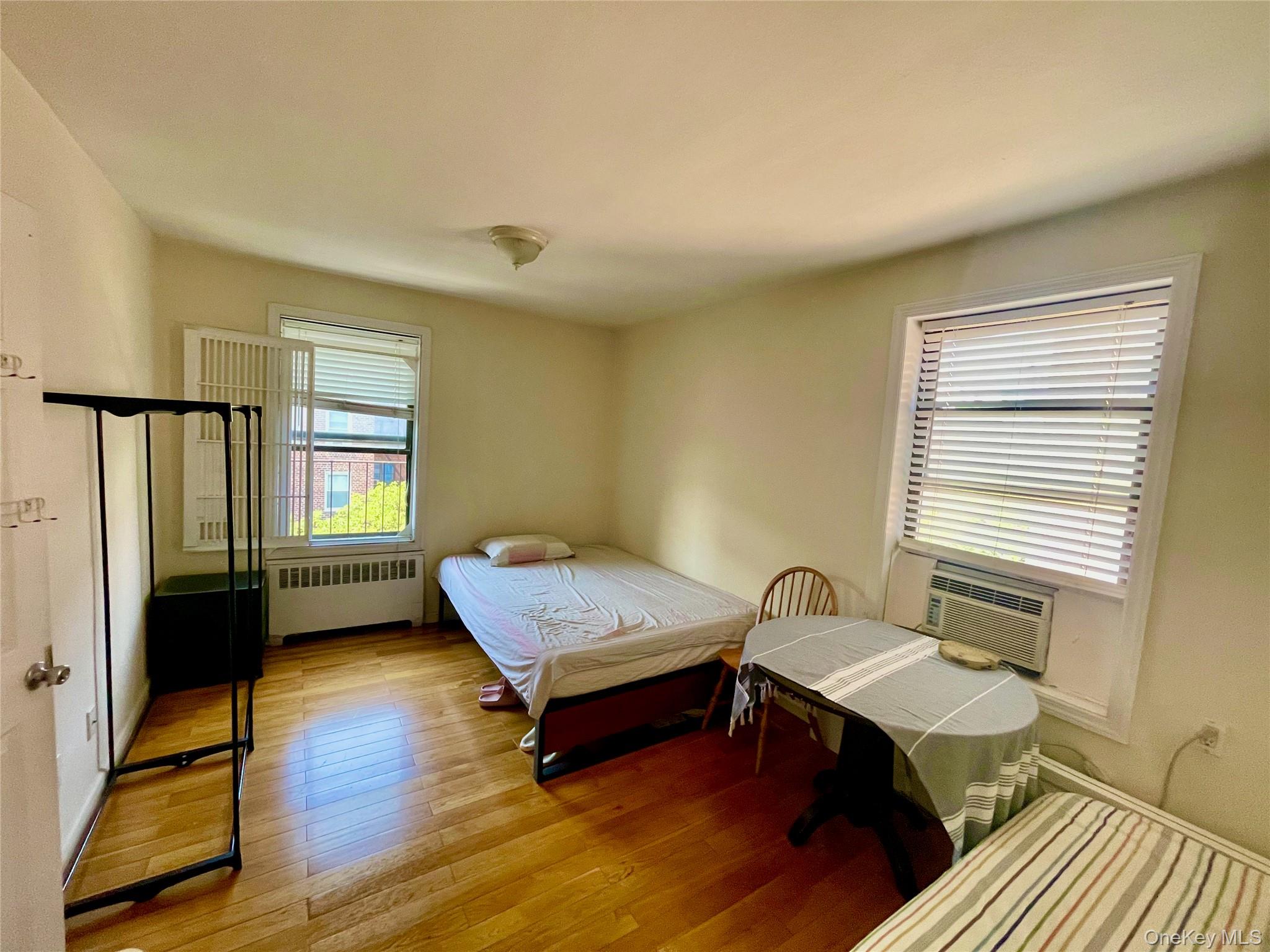44-25 Macnish Street, Unit 5B Queens, NY 11373 - Photo 10 of 19 a bedroom with a bed and wooden floor