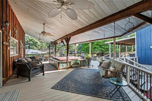 a view of a patio with table and chairs potted plants with wooden floor and fence