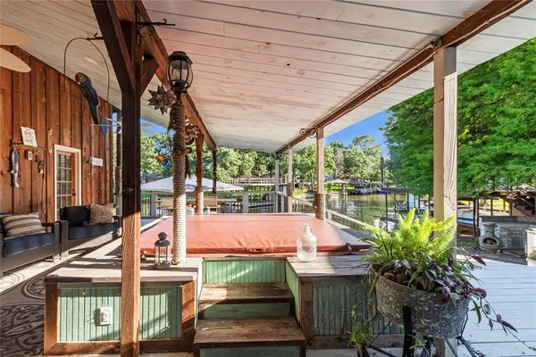 a view of a patio with table and chairs potted plants with wooden floor and fence