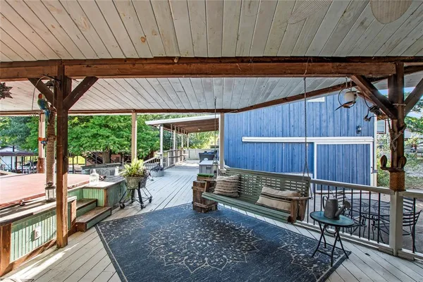 a view of a backyard with wooden floor and outdoor seating