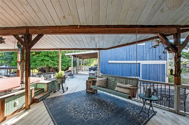 a view of a backyard with wooden floor and outdoor seating