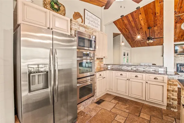 a kitchen with stainless steel appliances granite countertop a refrigerator and a stove