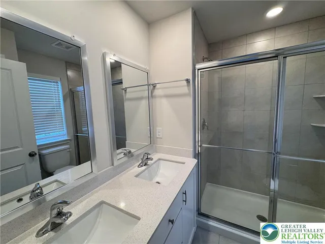 a bathroom with a sink vanity granite tub shower and mirror