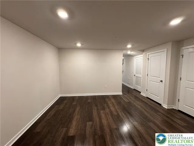a view of an empty room with wooden floor