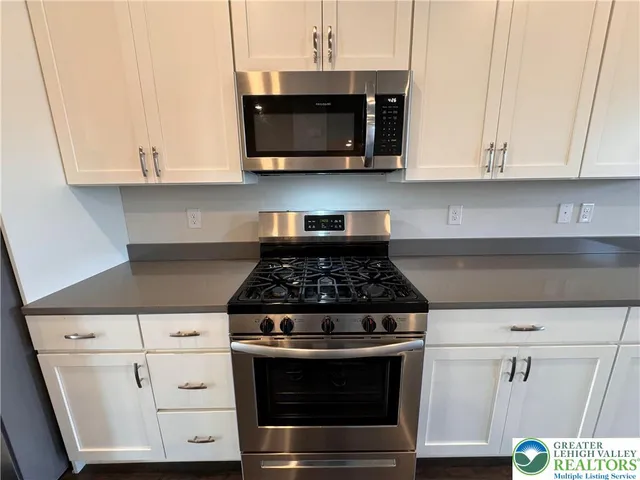 a stove top oven sitting inside of a kitchen