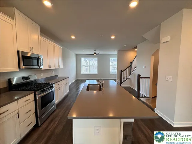 a kitchen with kitchen island a sink stove and refrigerator