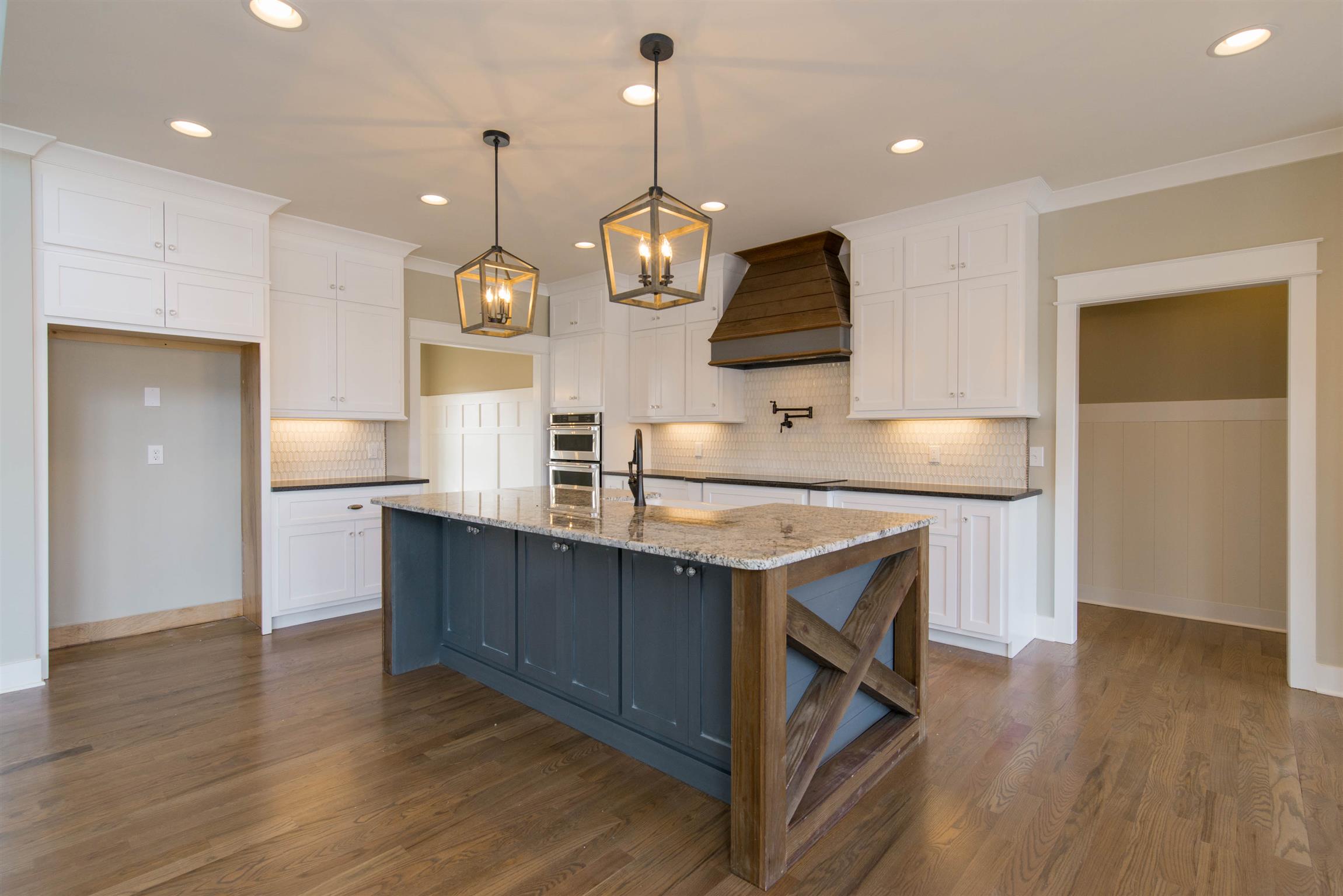 6988 Williams Road Christiana, TN 37037 - Photo 12 of 30 BEAUTIFUL CUSTOM KITCHEN. Custom cabinets featuring timber "X" on island. Potfiller. Undercabinet lighting.Farmhouse sink, ALL KITCHENAID APPLIANCES. Custom pendant lighting. TIle backsplash.5 burner cooktop and lots more.