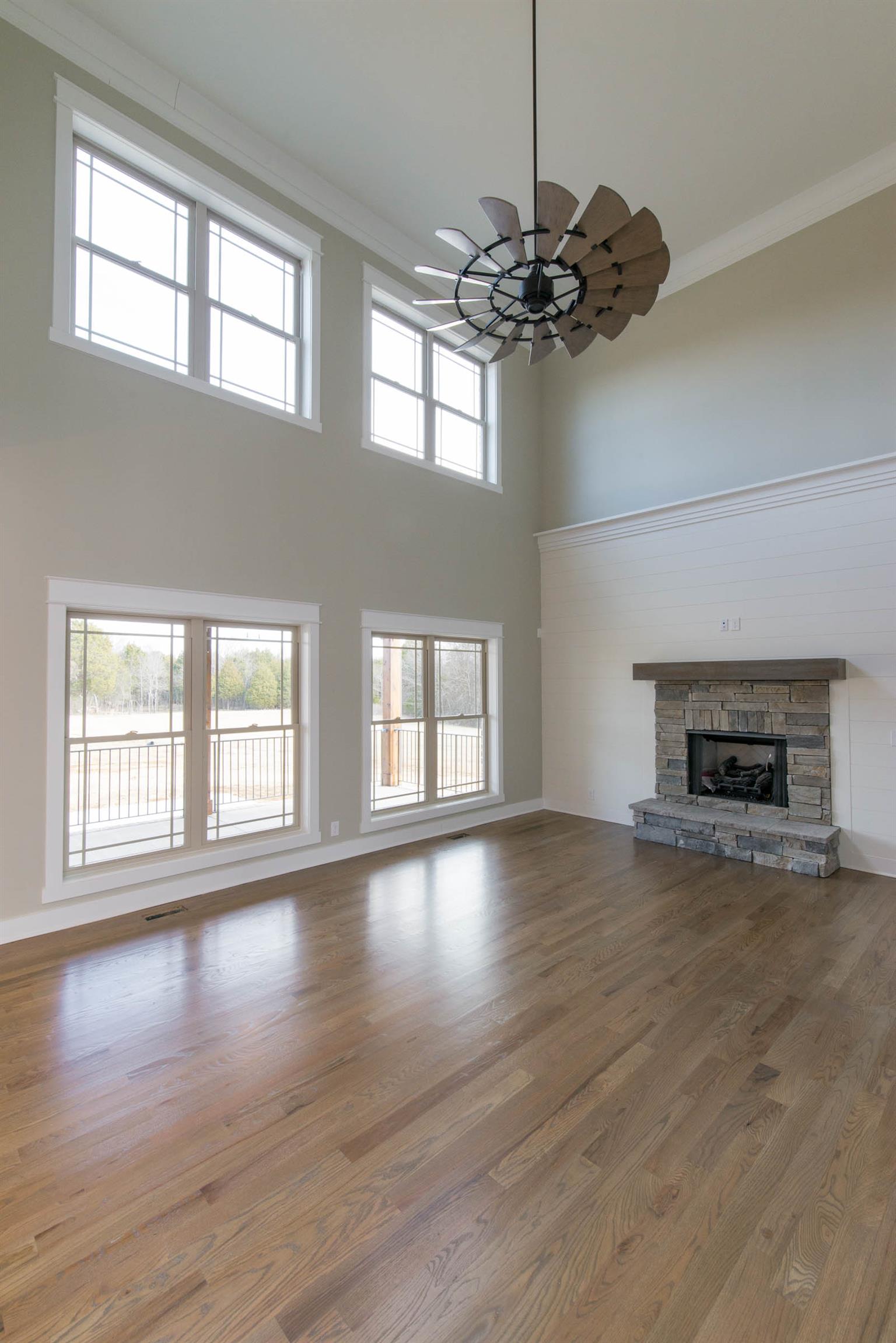 6988 Williams Road Christiana, TN 37037 - Photo 9 of 30 The two story great room that is open to the kitchen. AMAZING CUSTOM WINDMILL FAN.Shiplap feature wall with gas fireplace makes this two story room feel warn and cozy.