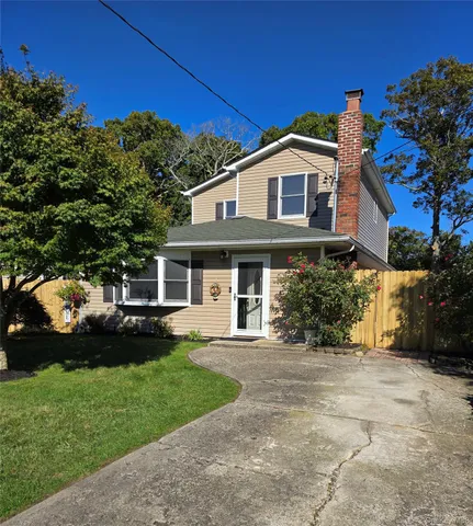 a front view of a house with a garden and yard