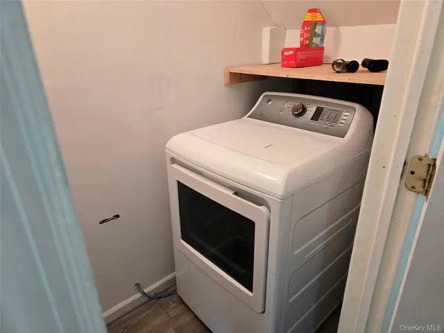 a view of an empty room with wooden floor and a ceiling fan
