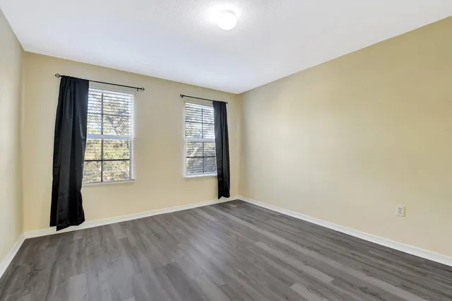 a view of an empty room with wooden floor