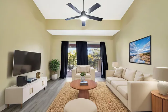 an empty room with wooden floor and a ceiling fan