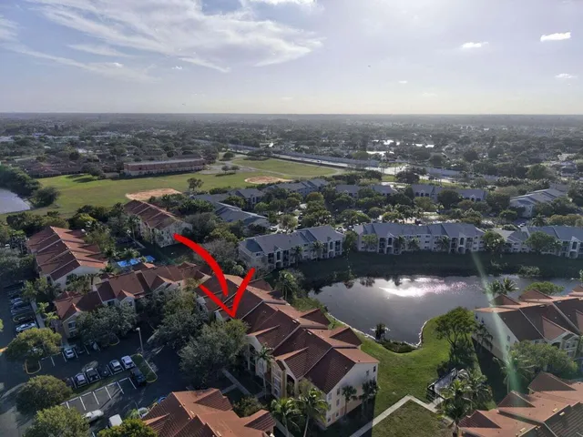 an aerial view of residential houses with outdoor space and trees
