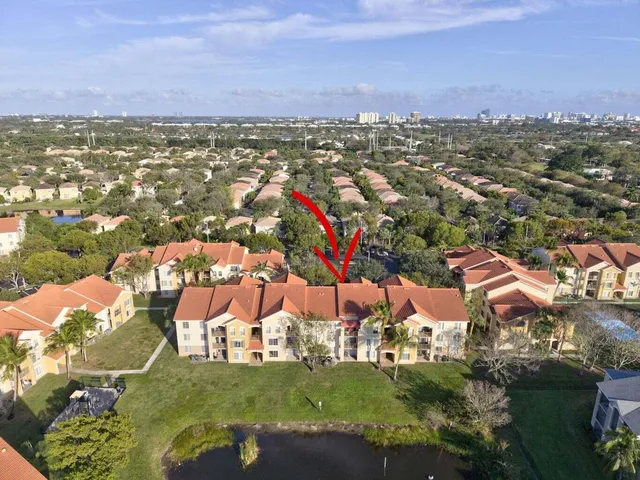 a view of a white house with a big yard and plants