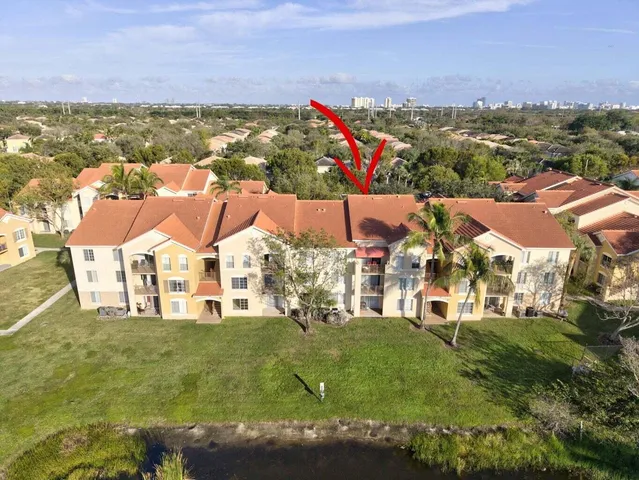 an aerial view of a house with a yard and lake view