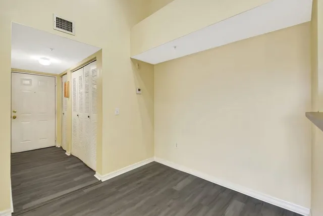 a view of an empty room with wooden floor