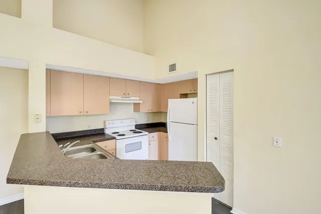 a kitchen with stainless steel appliances granite countertop a sink refrigerator and stove