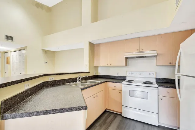 a kitchen with granite countertop white cabinets and white appliances