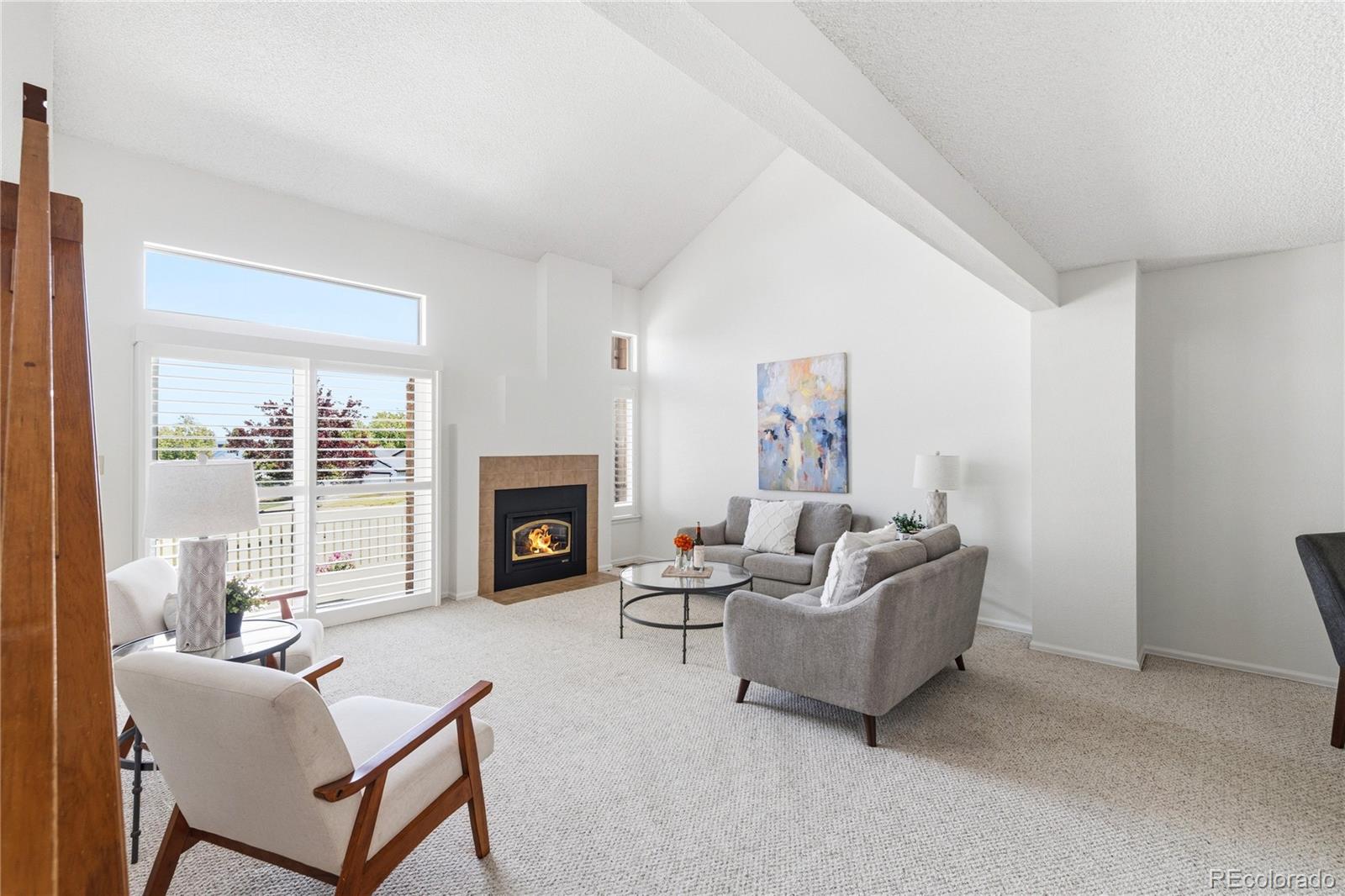 155 Blue Spruce Court Highlands Ranch, CO 80126 - Photo 3 of 29 a living room with furniture a fireplace and a large window