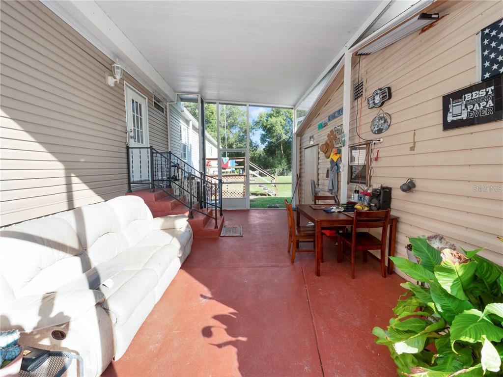 3201 Tenoroc Mine Road Lakeland, FL 33805 - Photo 35 of 48 a view of a patio with table and chairs potted plants with wooden floor and fence