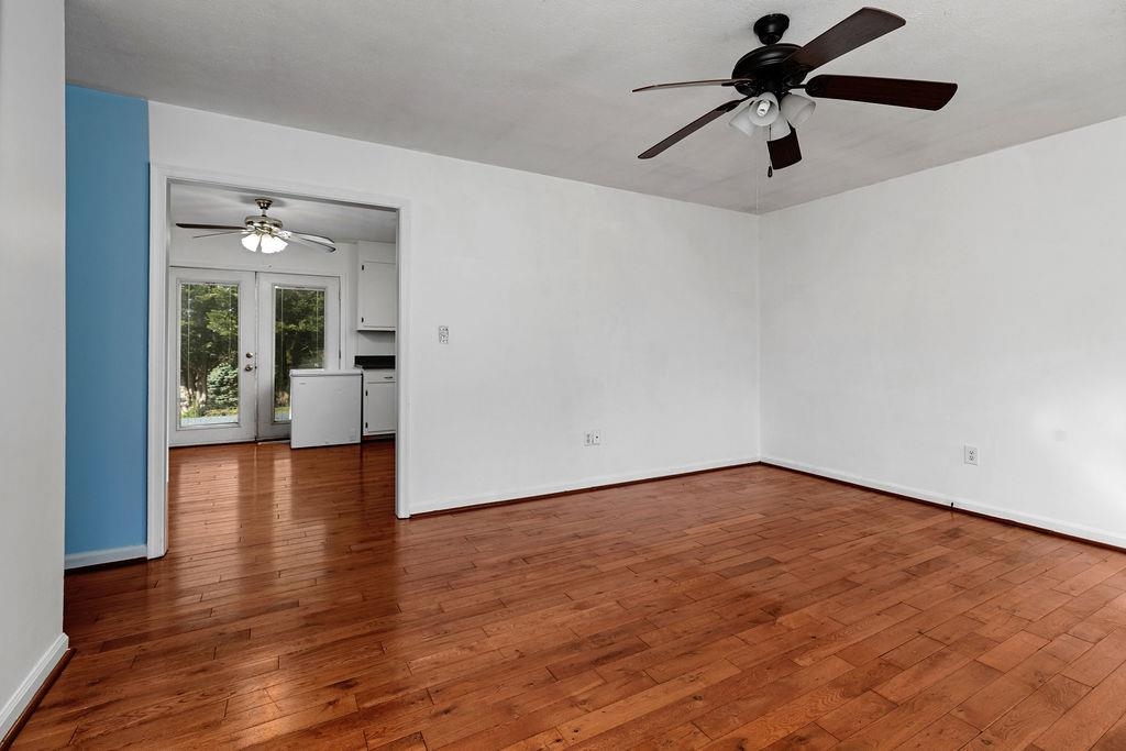 66 Hayrick Road Waynesboro, VA 22980 - Photo 10 of 26 an empty room with wooden floor chandelier fan and windows