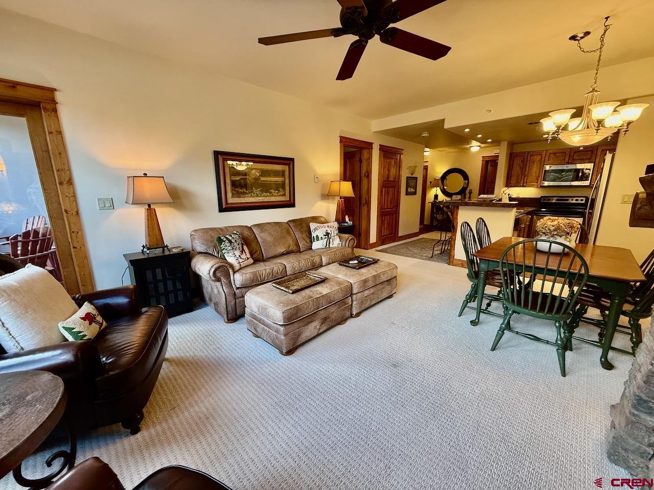 9 Hunter Hill Road, Unit 205 Crested Butte, CO 81225 - Photo 8 of 28 a spacious bedroom with a bed a couch and a chandelier