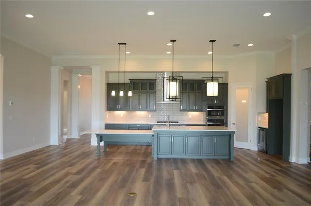 a large kitchen with granite countertop a large counter top stainless steel appliances and cabinets