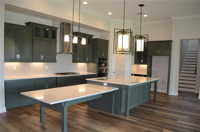 a kitchen with kitchen island a counter space a sink appliances and cabinets