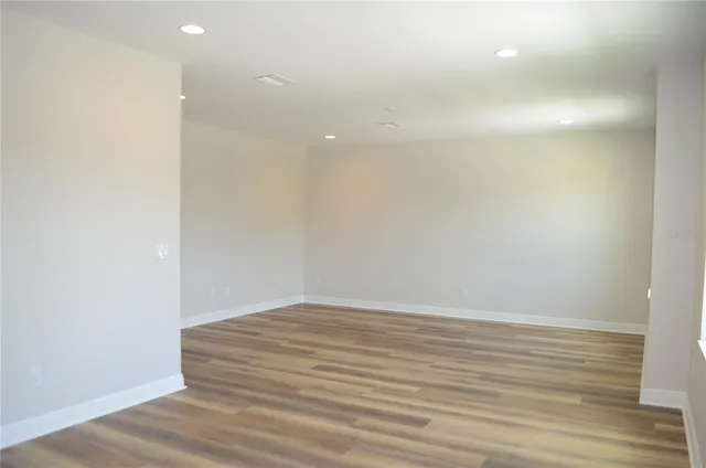 a view of an empty room with wooden floor