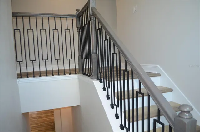 a view of staircase with railing and white walls