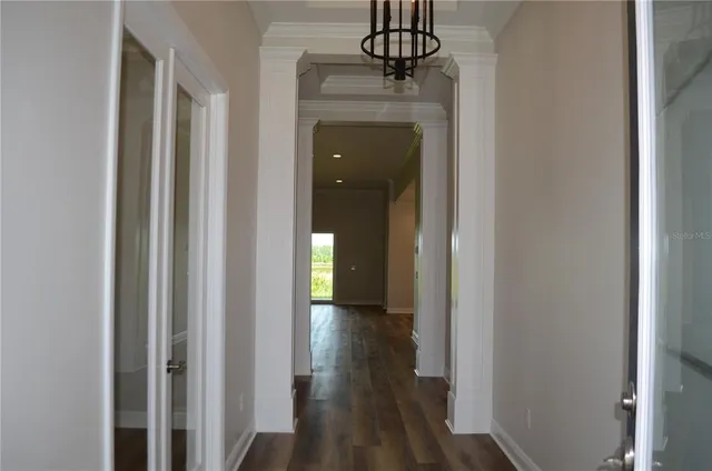 a view of a hallway with wooden floor and staircase