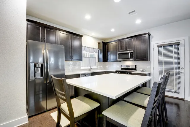 a kitchen with kitchen island a dining table and chairs