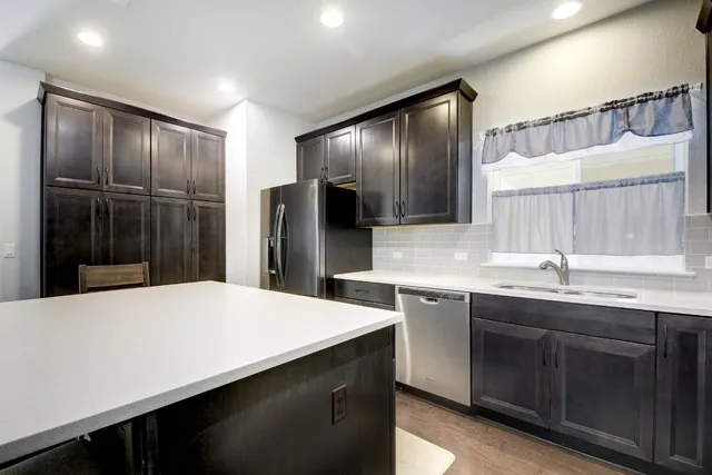 a kitchen with stainless steel appliances a sink and a refrigerator