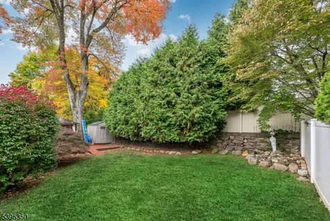 a view of a backyard with table and chairs and a large tree