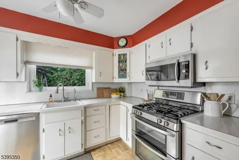 a kitchen with white cabinets and appliances