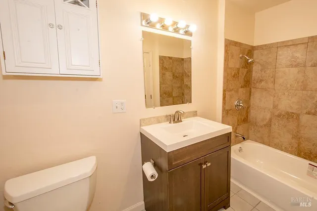 a bathroom with a granite countertop sink toilet and mirror
