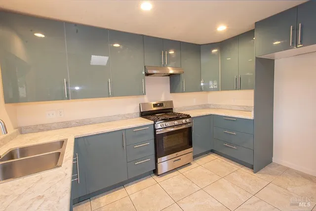 a kitchen with kitchen island granite countertop a stove and a refrigerator