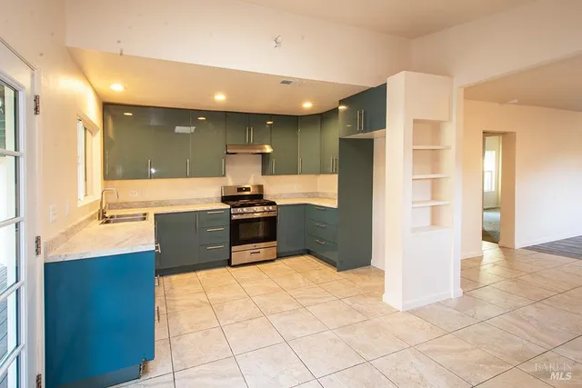 a kitchen with stainless steel appliances kitchen island granite countertop a refrigerator and a sink