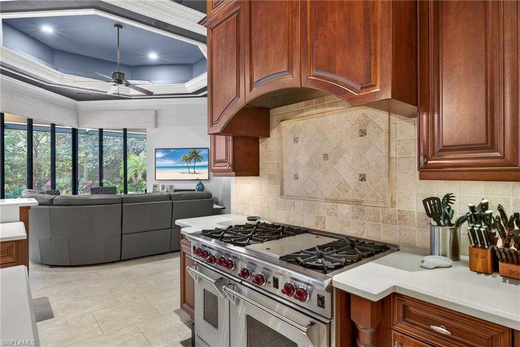 16488 Felicita Court Naples, FL 34110 - Photo 11 of 50 a kitchen with granite countertop a stove and a sink