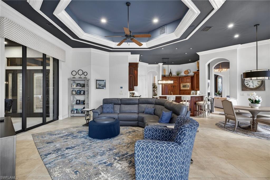 16488 Felicita Court Naples, FL 34110 - Photo 13 of 50 a living room with furniture a ceiling fan and a rug
