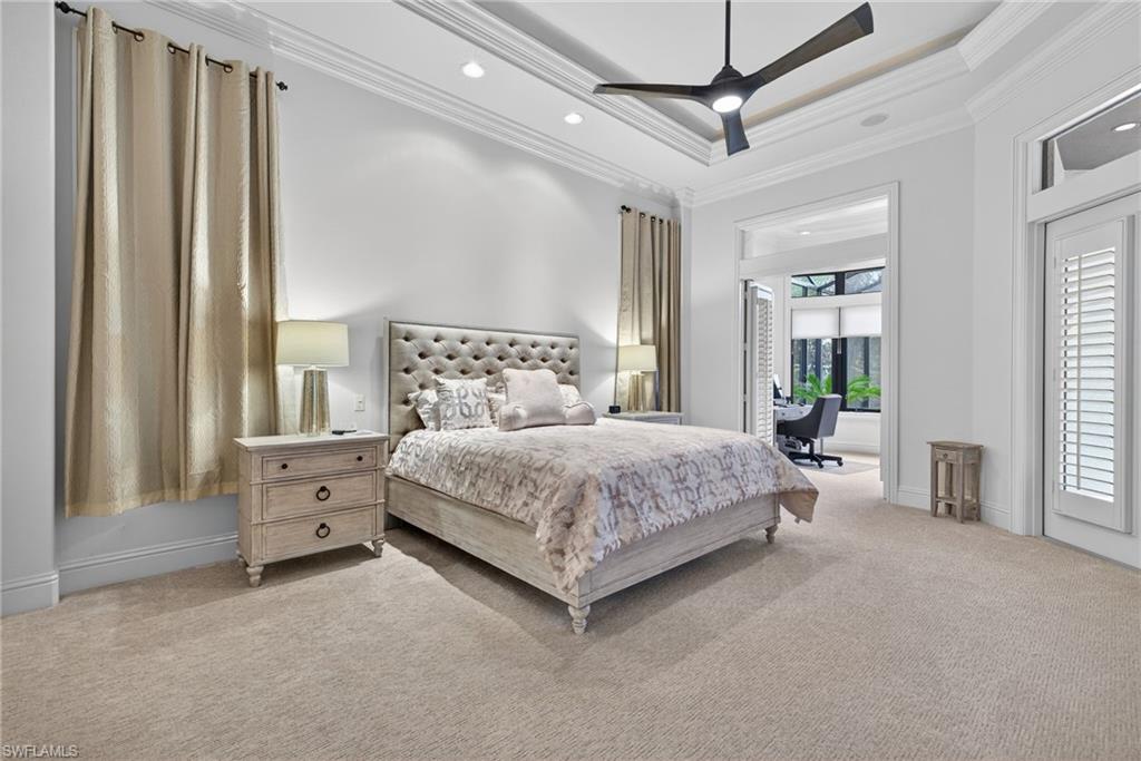 16488 Felicita Court Naples, FL 34110 - Photo 16 of 50 a bedroom with a large bed and a chandelier fan