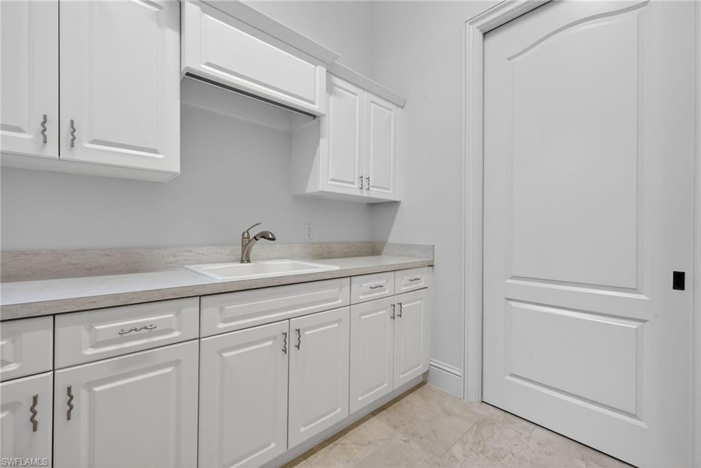 16488 Felicita Court Naples, FL 34110 - Photo 34 of 50 a kitchen with white cabinets and sink