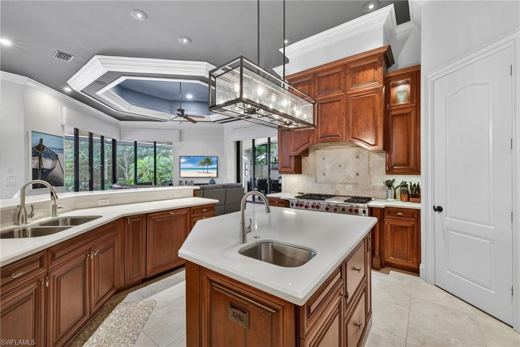 16488 Felicita Court Naples, FL 34110 - Photo 9 of 50 a kitchen with stainless steel appliances granite countertop a sink a stove and a refrigerator