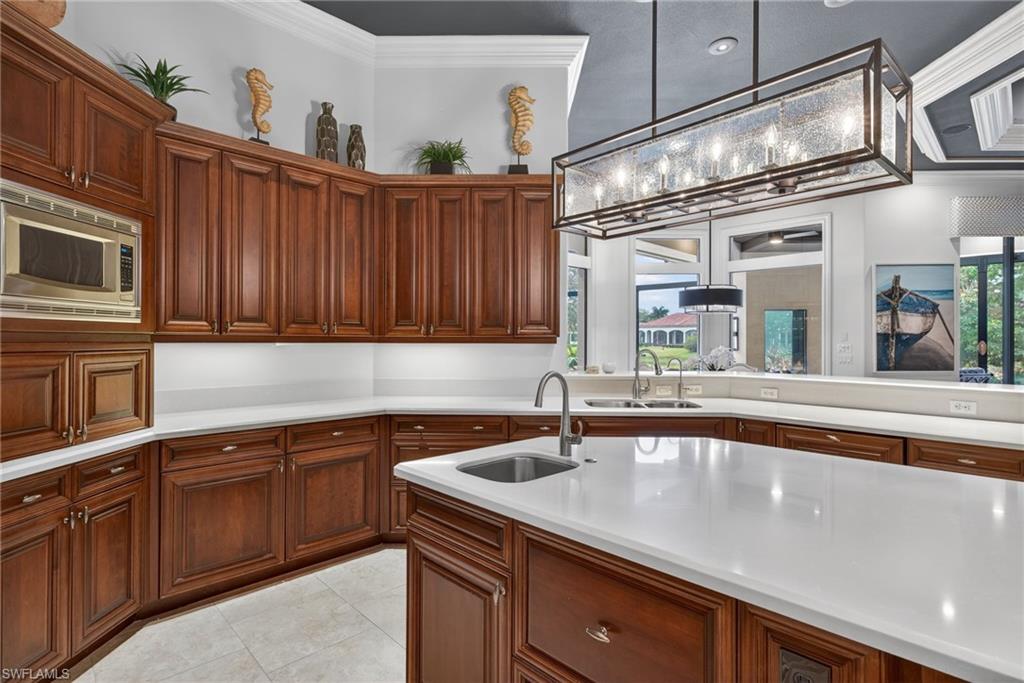 16488 Felicita Court Naples, FL 34110 - Photo 10 of 50 a kitchen with stainless steel appliances granite countertop a sink and cabinets