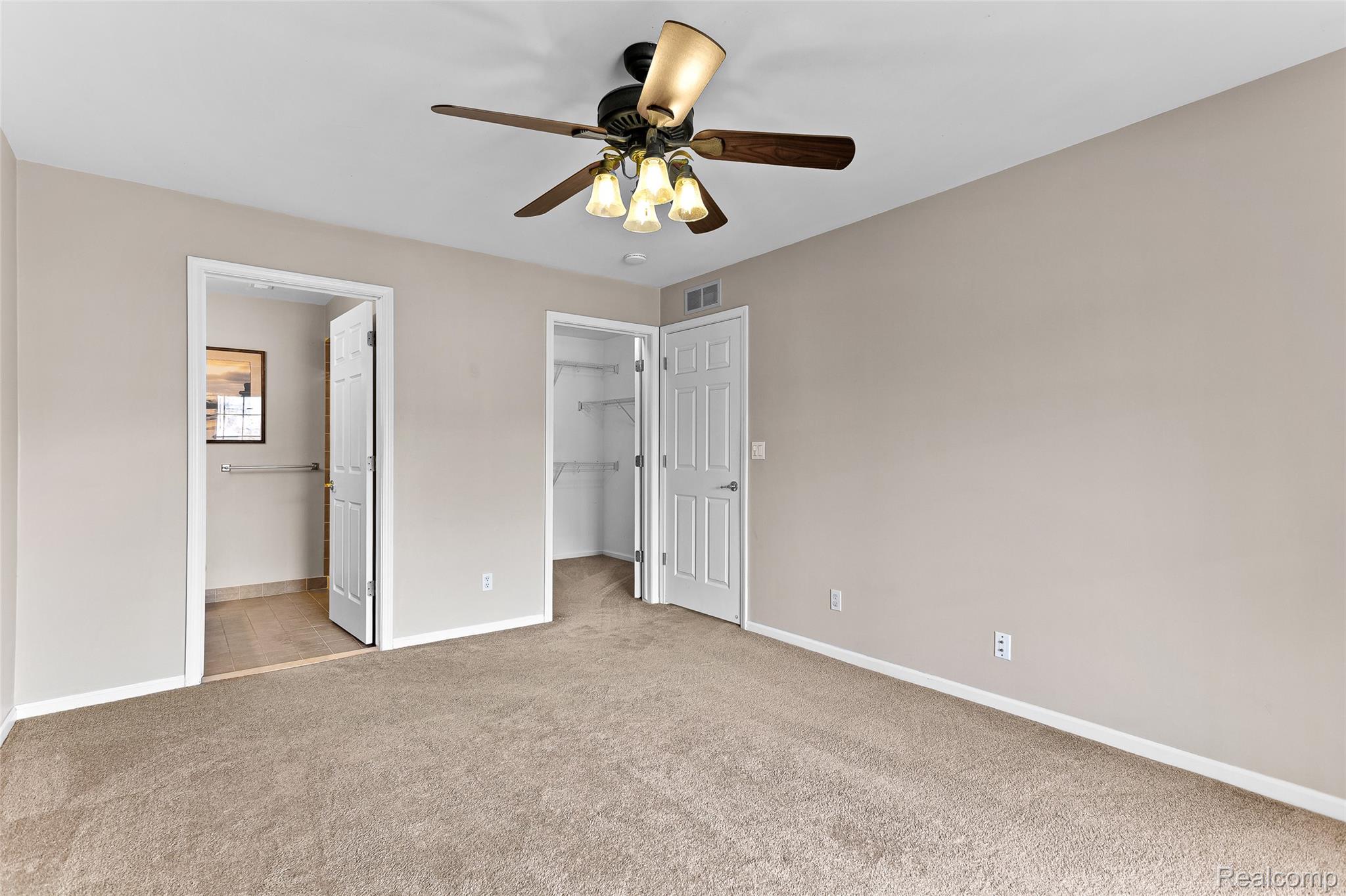 3553 Oakmonte Boulevard Rochester, MI 48306 - Photo 13 of 42 Carpeted interior space featuring a ceiling fan with integrated lighting, two paneled doors, and an open doorway leading to a tiled area