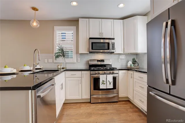 a kitchen with white cabinets stainless steel appliances and sink