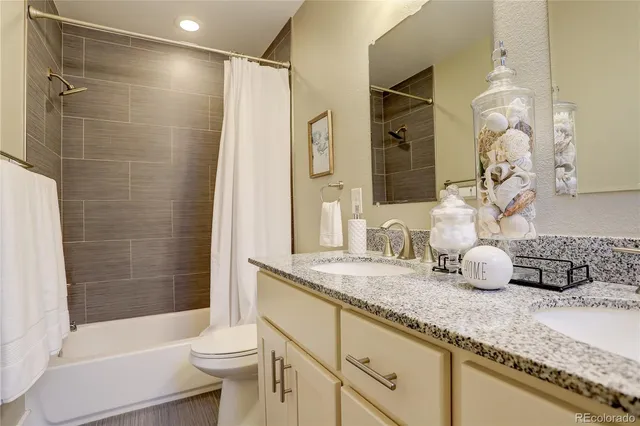 a bathroom with a granite countertop sink a toilet and bathtub